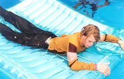 Pool float fully clothed in jeans and hoodie